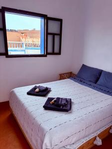 a bedroom with a bed with two towels on it at Hôtel grand Atlas in Mirleft