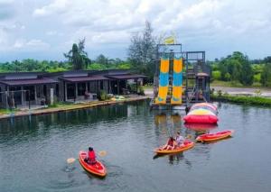 a group of people riding on boats in the water at มีดี ฟาร์ม โฮมสเตย์ in Ban Klam