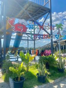 a theme park with plants in front of a roller coaster at มีดี ฟาร์ม โฮมสเตย์ in Ban Klam