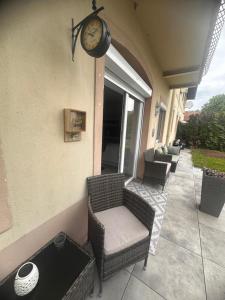 a clock on the side of a porch with a chair at Shine Home in Klagenfurt