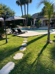 a yard with a pool and palm trees and a street light at Luxueuse villa piscine et jacuzzi in Saint Paul de Vence