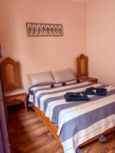 a bedroom with a bed with two bags on it at Hôtel grand Atlas in Mirleft