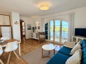 a living room with a blue couch and a table at White Sands 3.07 in Arenal d'en Castell