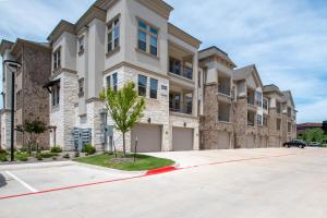 a large apartment building with a car parked in the driveway at Luxury McKinney Resort Stay Near Universal Kids with Pool & Gym in McKinney