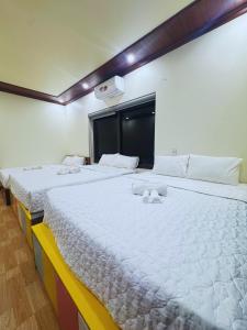 two beds in a room with white sheets at Tam Coc Sylvani Homestay in Vũ Lâm