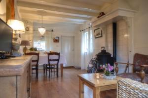 een keuken en een woonkamer met een tafel en stoelen bij Oes-Tilber in Zweeloo