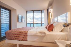 a bedroom with a bed with a large window at Orbi City Central Aparthotel in Batumi +108 photos