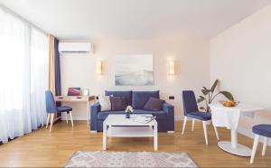 a living room with a blue couch and a table at Orbi City Central Aparthotel in Batumi