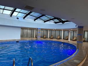a large swimming pool in a hotel room at Orbi City Central Aparthotel in Batumi