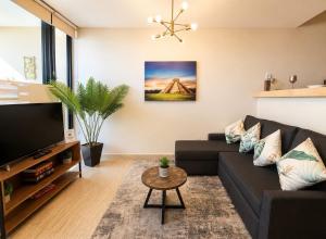 a living room with a couch and a tv at Syrena Luxury Caribbean - Heart of Playa del Carmen - Sea Views in Playa del Carmen