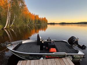 a boat is docked at a dock on a lake at Villa Norppa in Punkaharju