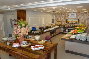 a kitchen with a bunch of food on display at Hotel Castelo in Gravatal