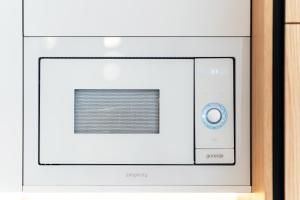 a white microwave oven with a blue button at Maria Premium BELLA VISTA in Baošići