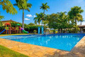 a swimming pool with a playground and a slide at Hotel Castelo in Gravatal