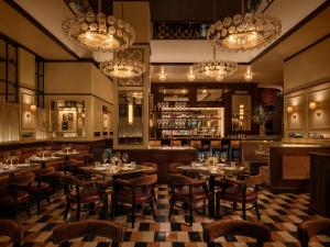 a restaurant with tables and chairs and a bar at CIVILIAN Hotel in New York