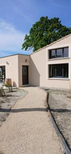 a house with a gravel driveway in front of it at Gite des Egadillias climatisé in Marsanne