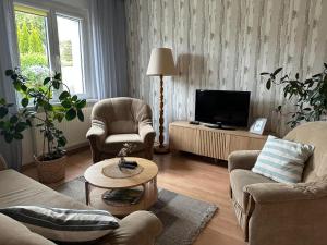 a living room with two chairs and a television at Apartamenty Vega in Charzykowy +60 photos