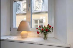 a candle and a vase with flowers in a window at FeWo3 in Lindau +1 photo