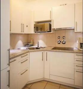 a white kitchen with white cabinets and a sink at FeWo3 in Lindau