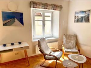 a living room with two chairs and a table and a window at FeWo3 in Lindau