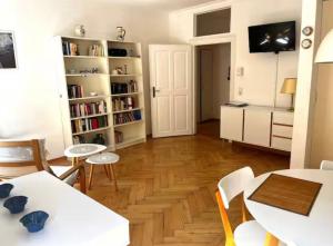 a living room with a table and chairs and bookshelves at FeWo3 in Lindau