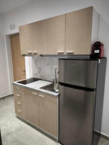 a kitchen with a stainless steel refrigerator and a sink at Fox Studios in Paralia Sikias
