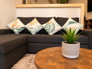 a black couch with pillows and a table with a plant at Syrena Luxury Caribbean - Heart of Playa del Carmen - Sea Views in Playa del Carmen +33 photos