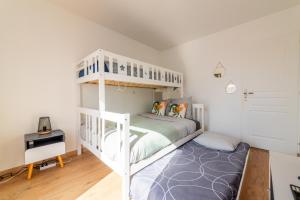 a bedroom with a white bunk bed and a desk at Warm cocoon - parking included in Asnières-sur-Seine