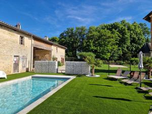 a backyard with a swimming pool and grass at Gîtes du Château de Crespy in Crespy-le-Neuf
