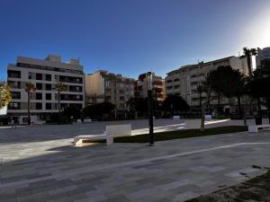 a park with a white bench in a city at Roque Home Stay in La Mata
