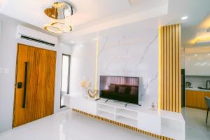 a living room with a television on a white wall at Amethyst Bcd in Bacolod