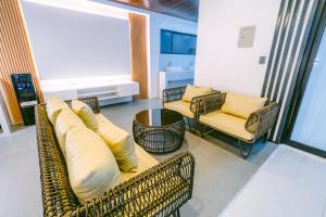 a living room with couches and a table and chairs at Amethyst Bcd in Bacolod