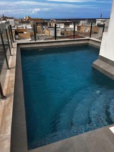 a swimming pool on the roof of a building at Roque Home Stay in La Mata