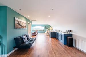 a living room with a couch and a kitchen at Corlea Studio in Dunwish