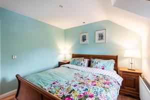 a bed in a bedroom with blue walls and two lamps at Corlea Studio in Dunwish