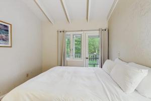 a white bed in a room with a window at Seasons 307 in Warren