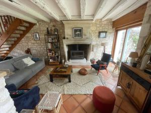 a living room with a couch and a fireplace at Villa avec piscine in Soyaux