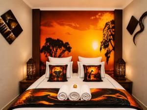 a bedroom with a bed with a painting on the wall at Hartbeespoort - El-Tsuri Guest Resort in Hartbeespoort
