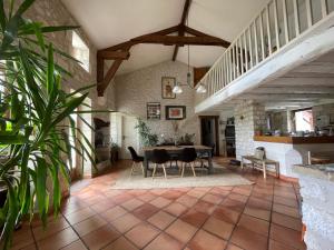 a large living room with a table and chairs at Villa avec piscine in Soyaux