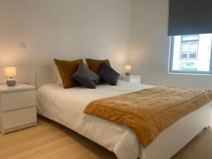 a bedroom with a large bed with pillows and a window at Ria & Mar Collection I in Aveiro