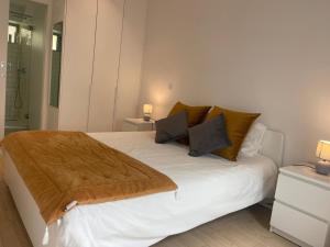 a bedroom with a white bed with a brown blanket on it at Ria & Mar Collection I in Aveiro
