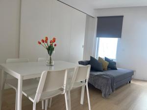 a dining room with a white table and a couch at Ria & Mar Collection I in Aveiro