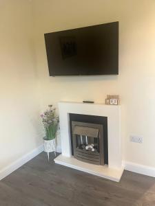 a living room with a fireplace with a flat screen tv at Atlantic way Apartment in Sligo