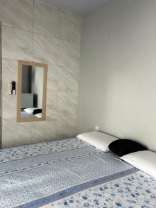 a bedroom with a bed with a mirror on the wall at Pousada das Redes in João Pessoa