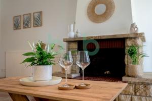 a table with two wine glasses and a potted plant at Casa Cyra in Alexandroupoli
