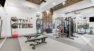 a gym with several treadmills and exercise equipment at Luxury McKinney Resort Stay Near Universal Kids with Pool & Gym in McKinney