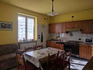a kitchen with a table and a kitchen with a table and chairs at Residenza Nonna Lucia in Roccaforte Mondovì