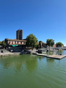 a view of a river with buildings and a dock at La Galiote in Agde +23 photos