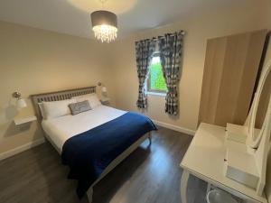 a bedroom with a bed with a blue blanket and a window at Atlantic way Apartment in Sligo