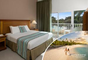 a hotel room with a bed and a view of a beach at Hodelpa Garden Suites - All Inclusive in Juan Dolio
